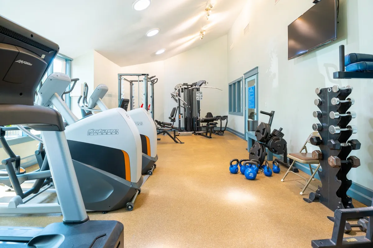 A well-equipped fitness center featuring treadmills, weight machines, free weights, and kettlebells. The space is bright and energizing, inviting guests to pursue their fitness routines or join group classes.